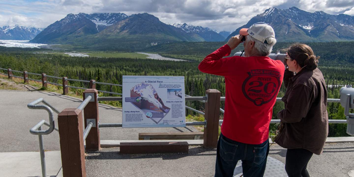 Two people with binoculars admiring a mountain
