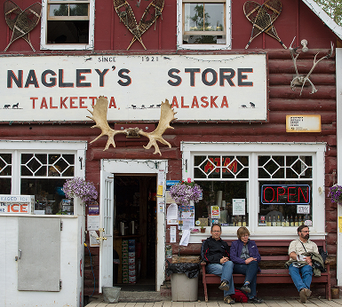 A rustic general store with a large sign reading 'Nagley's Store' and moose antlers above the entrance in Mat-Su, Alaska
