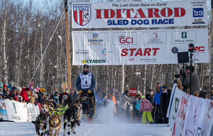 Mushers and sled dogs race through the snow at the Iditarod Trail Sled Dog Race in Mat-Su, Alaska