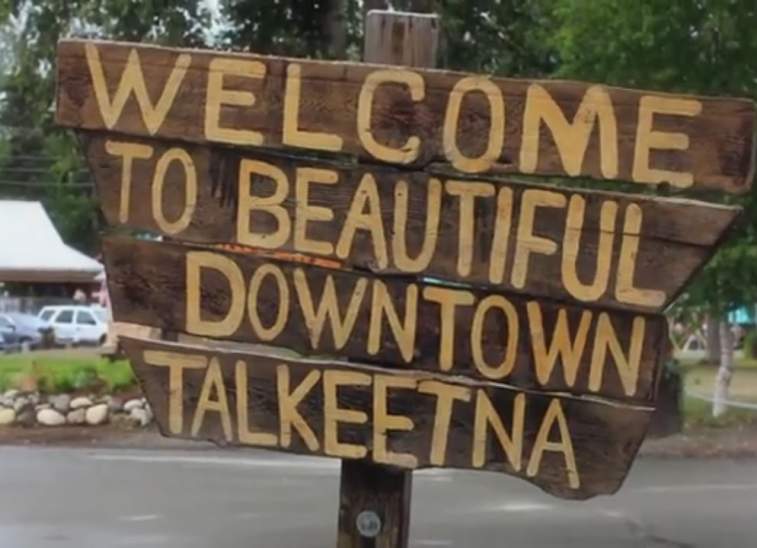 A rustic wooden sign welcomes visitors to the beautiful downtown area of Talkeetna, Alaska in Mat-Su, Alaska