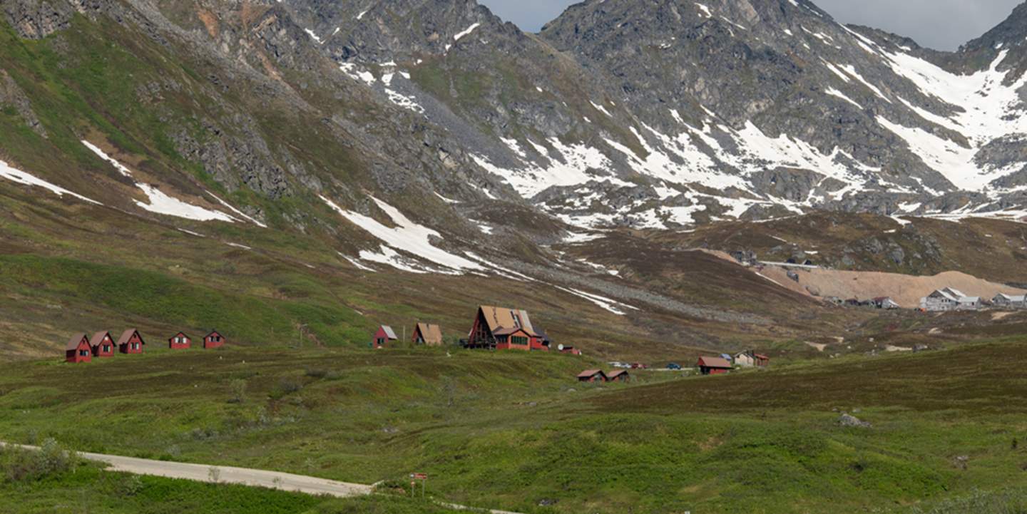 A picturesque mountain village nestled among snow-capped peaks and lush green meadows in Mat-Su, Alaska
