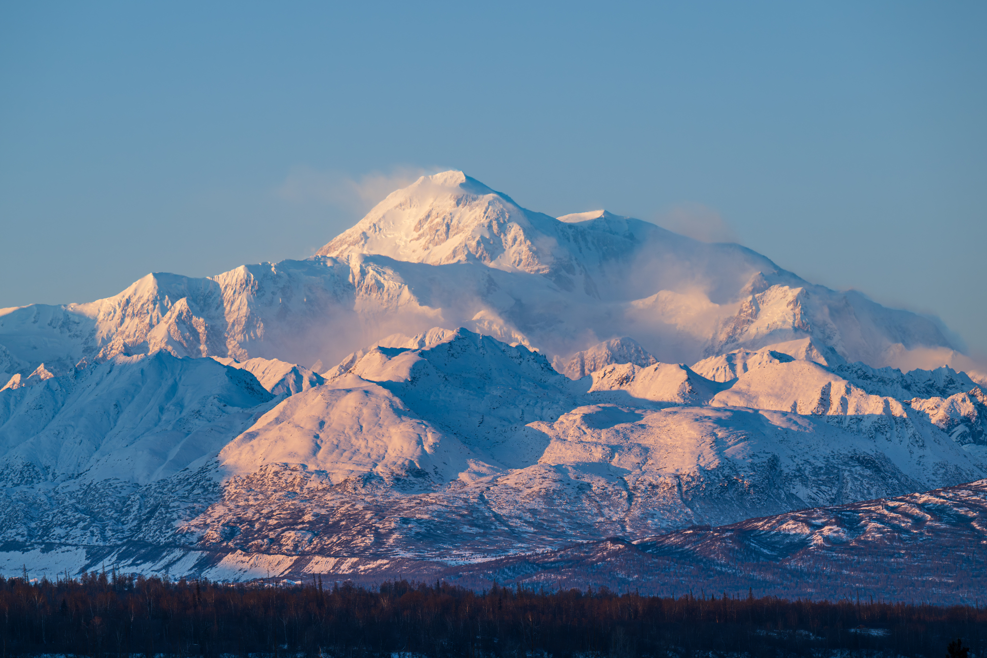 Majestic snow-capped mountain range bathed in golden light at sunrise in Mat-Su, Alaska