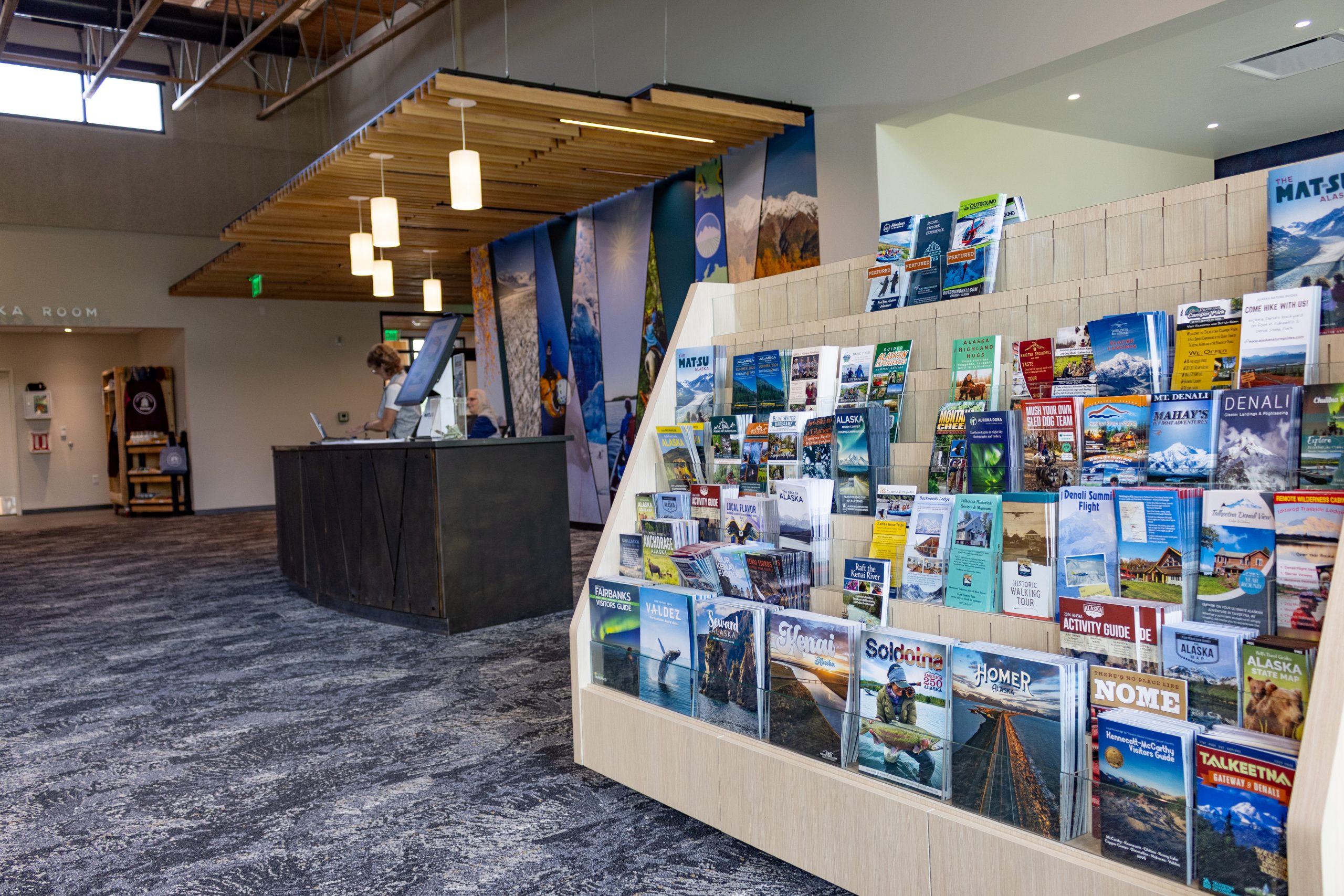 A visitor center interior with a brochure display rack and a reception desk in Mat-Su, Alaska