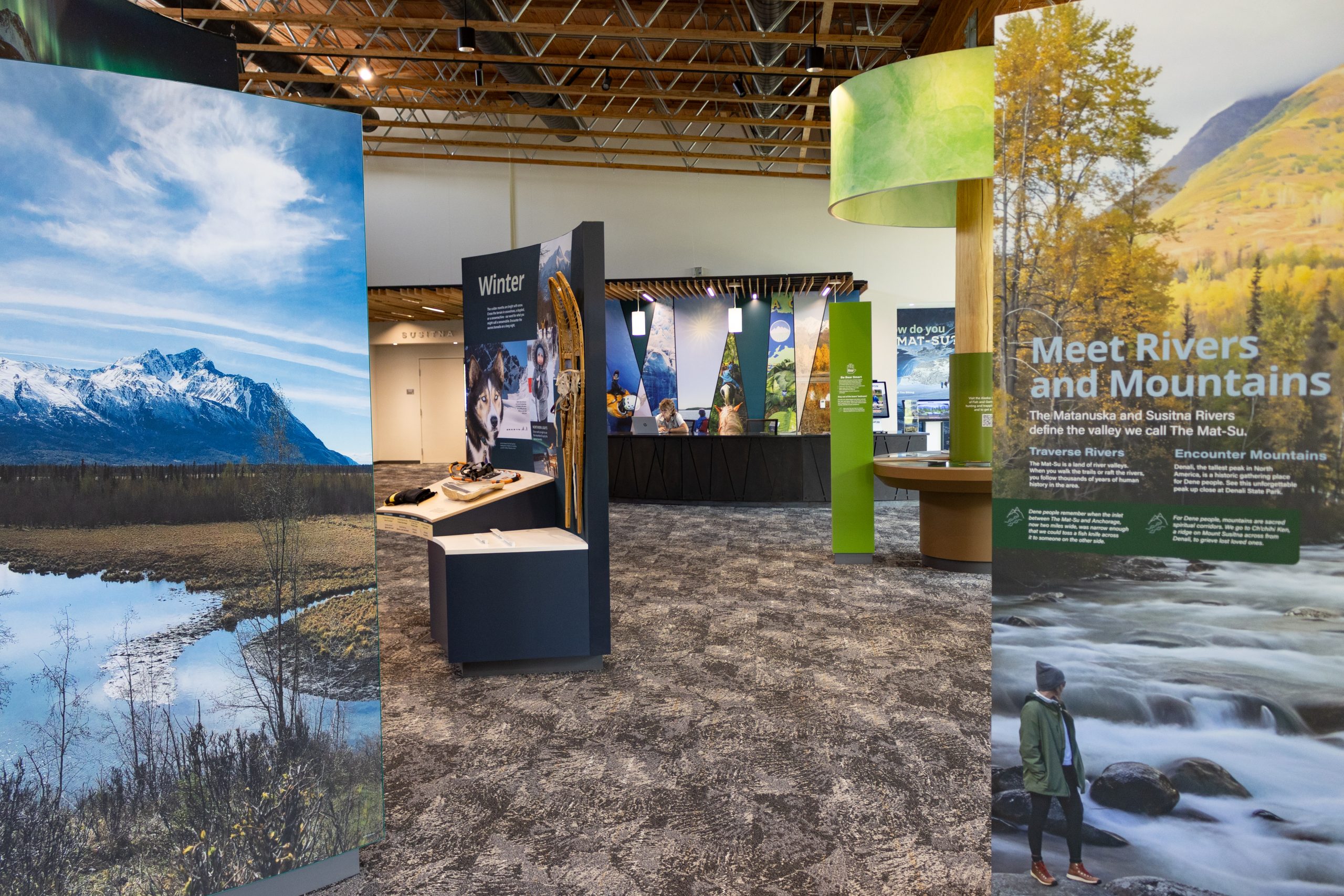 An interior view of a museum exhibit featuring nature-themed displays and informative signage in Mat-Su, Alaska